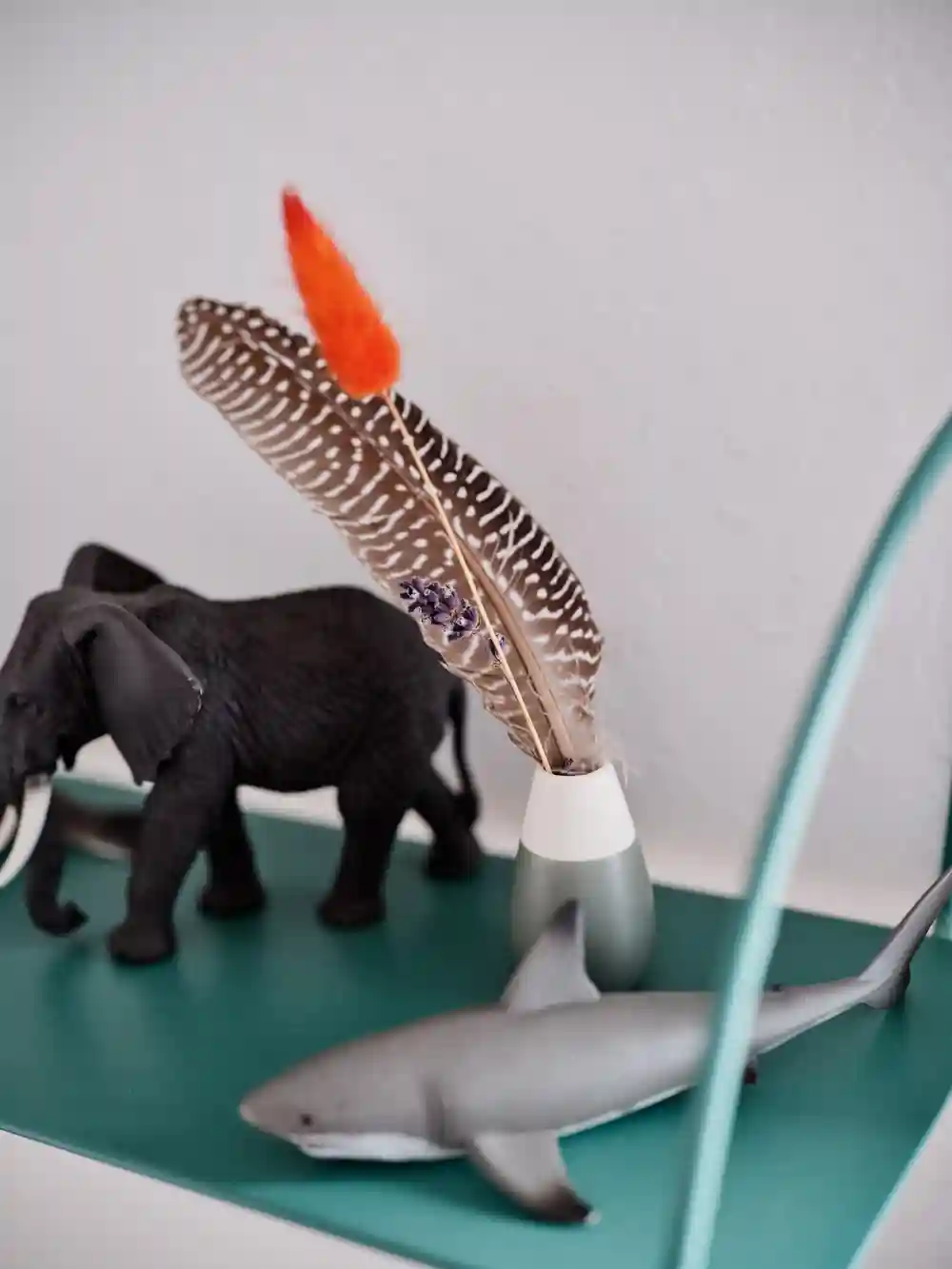 Detailaufnahme von einem Hai und Elefanten als Kinderspielsachen und einer Feder.